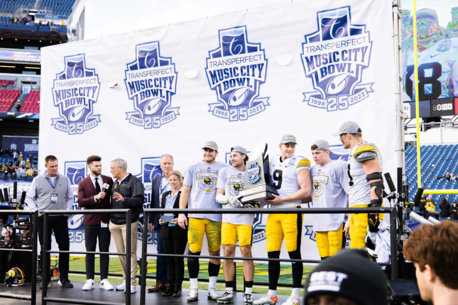 Iowa players hold up the Music City Bowl trophy after the Kentucky vs. Iowa Music City Bowl football game on Saturday, Dec. 31, 2022, at Nissan Stadium in Nashville, Tennessee. UK lost 21-0. Photo by Isabel McSwain | Staff