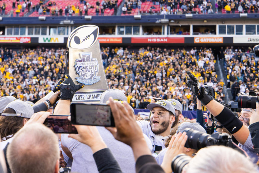 Iowa players celebrate with the trophy after the Kentucky vs. Iowa Music City Bowl football game on Saturday, Dec. 31, 2022, at Nissan Stadium in Nashville, Tennessee. UK lost 21-0. Photo by Isabel McSwain | Staff