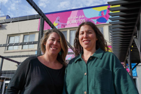 Artists Lynsay Christensen, left, and Hayley Harris, right, pose for a photo in front of their newly painted mural on Friday, Dec. 2, 2022, at girlsgirlsgirls Burritos in Lexington, Kentucky.