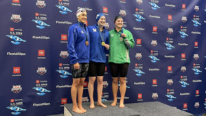 Kentucky swimmers Nick Caruso (left) and Gillian Davey (middle) pose alongside the silver-medal winning swimmer at the 2022 U.S Open in the Greensboro Aquatic Center in Greensboro, North Carolina, on Dec. 3, 2022. Photo provided by UK Athletics.