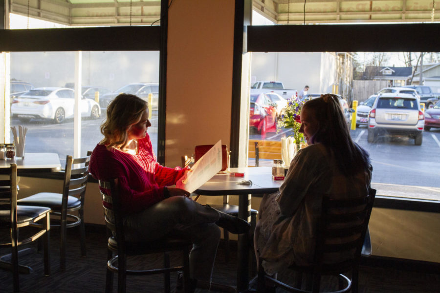 Ansley Colvin, left, and Brigid Whipp talk during their blind date on Sunday, Feb. 12, 2023, at Puccini’s Pizza Pasta in Lexington, Kentucky. Photo by Maria Rauh | Staff
