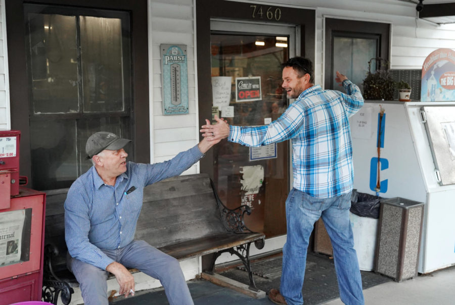 Store owner Dan Midkiff high-fives local patron Mike Stanley, Frankfort, Kentucky on Wednesday, Oct. 5, 2022. Photo by Bryce Towle.