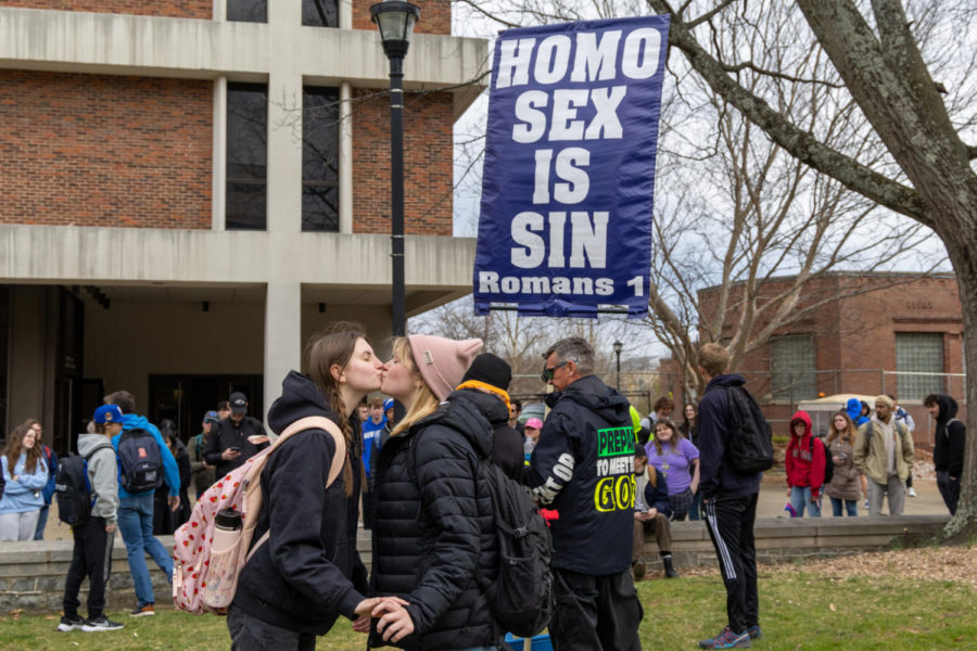 Kayla Walker, left, and Molly Godbey kiss during an anti-LGBTQ demonstration outside White Hall Classroom Building on Wednesday, March 8, 2023, at the University of Kentucky in Lexington, Kentucky. Photo by Travis Fannon | Staff