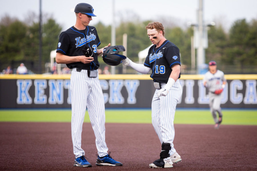 Kentucky Wildcats outfielder Nolan McCarthy (19) hands his helmet to a coach during the No.10 Kentucky vs. Dayton baseball game on Tuesday, April 4, 2023, in downtown Lexington in Lexington, Kentucky. Photo by Samuel Colmar | Staff