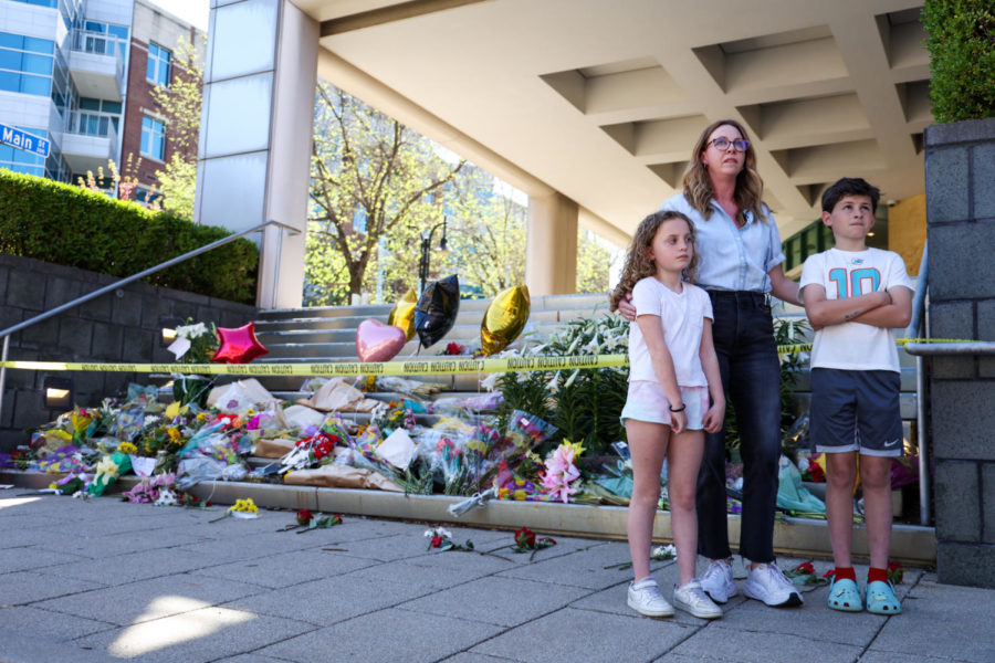 Keri Foy stands with her children in front of a memorial for the lives lost in the Louisville mass shooting while speaking on the impact that violence has on her children on Wednesday, April 12, 2023, at the Old National Bank in Louisville, Kentucky. Kentucky Lantern photo by Abbey Cutrer