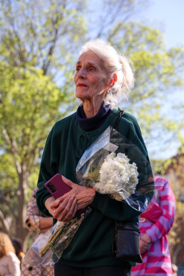 Mary Krider holds flowers during the community vigil honoring the victims of the Louisville mass shooting on Wednesday, April 12, 2023, at the Muhammad Ali Center plaza in Louisville, Kentucky. Kentucky Lantern photo by Abbey Cutrer