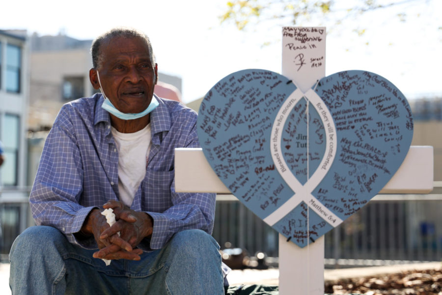 Arthur Hill rests next to a makeshift memorial display for Jim Tutt, one of the victims of the Louisville mass shooting, during the community vigil on April 12, 2023, at the Muhammad Ali Center plaza in Louisville, Kentucky. Photo by Abbey Cutrer