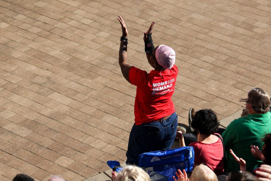A woman wearing a “Moms demand action” shirt claps at a speech during the community vigil honoring the victims of the Louisville mass shooting on Wednesday, April 12, 2023, at the Muhammad Ali Center plaza in Louisville, Kentucky. Kentucky Lantern photo by Abbey Cutrer