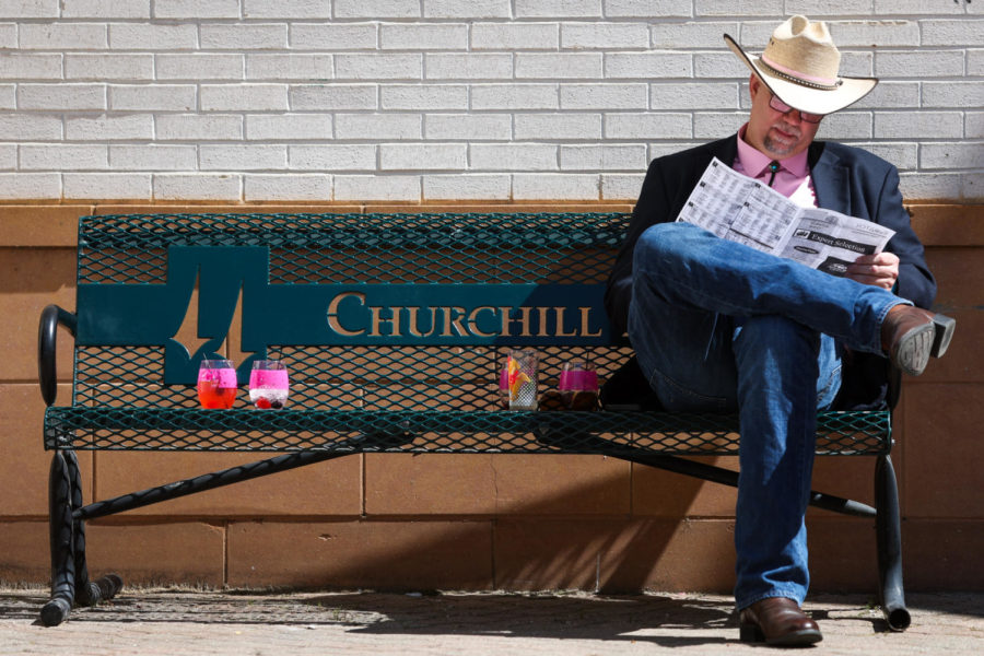 A Derby goer sits on a bench during the 149th Kentucky Derby on Friday, May 5, 2023, in Churchill Downs in Louisville, Kentucky. Photo by Samuel Colmar | Staff