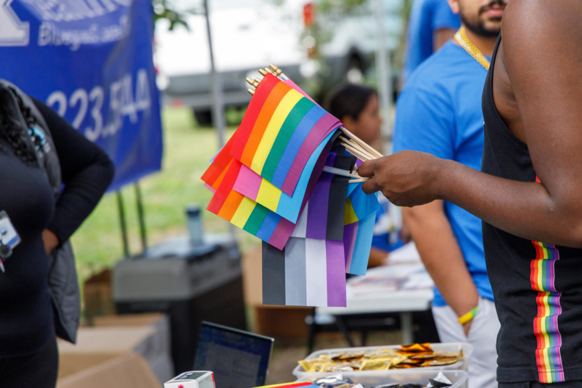 RJ Stone passes out Pride flags at Kentucky Black Pride fest on Saturday, Sep. 17, 2023, at Woodland park, Lexington, Kentucky. Photo by Matthew Mueller | Staff