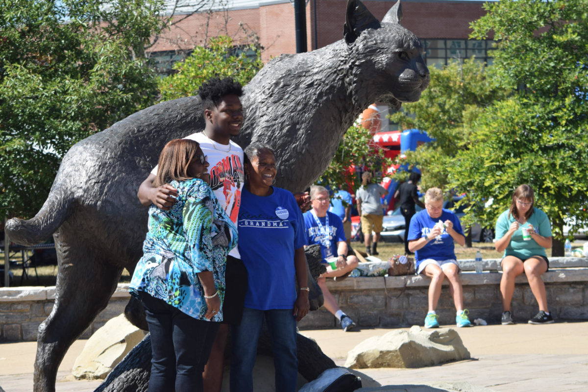A family poses for a photograph in front of the Bowman Statue at the University of Kentucky Family Weekend Tent Party on Saturday, Sep. 23, 2023 at Wildcat Alumni Plaza in Lexington, Kentucky. Photo by Gracie Moore | Staff