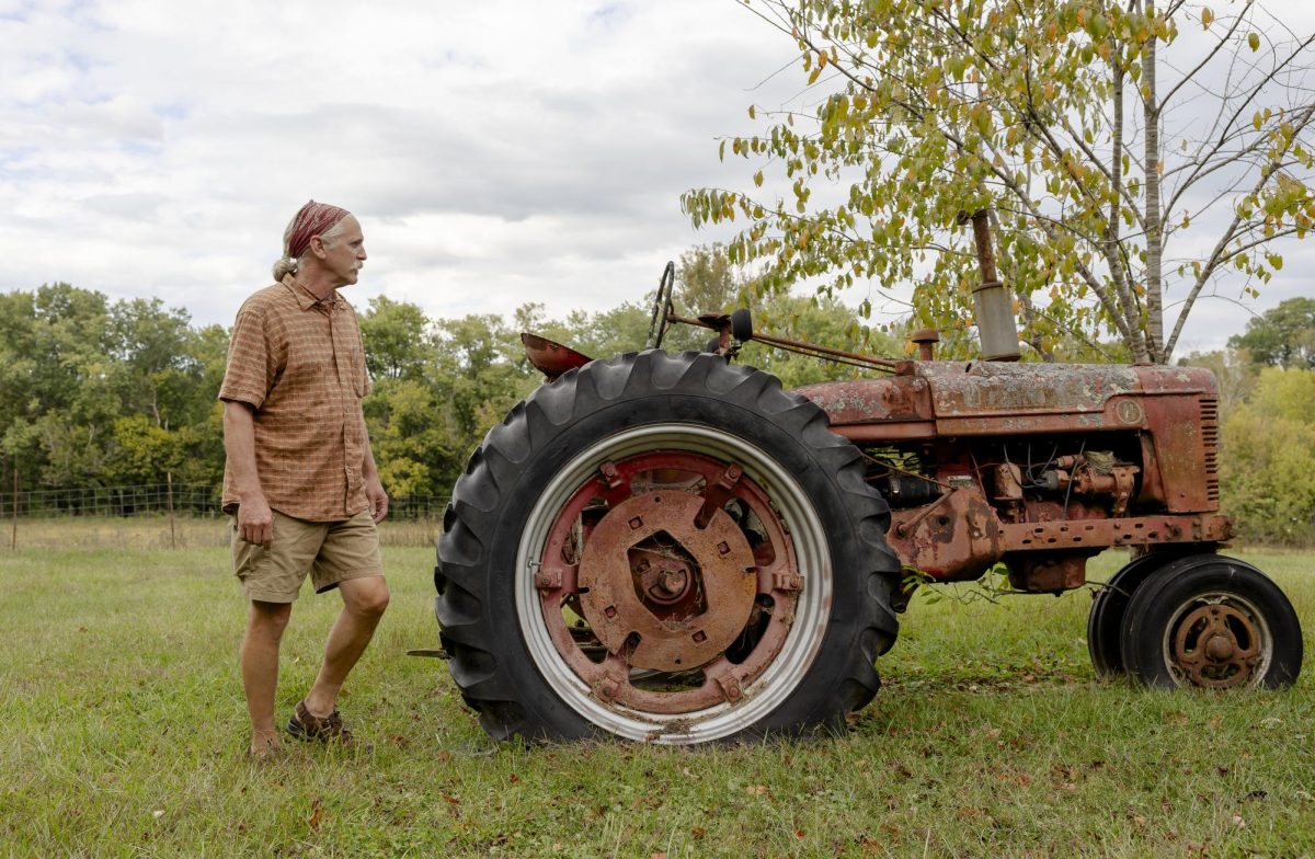 Keenan Bishop stands next to an old tractor on his father’s farm on Friday, Oct. 13, 2023, in Frankfort, Ky. Bishop said he used to ride and play on the tractor as a child. Photo by Rana Alsoufi