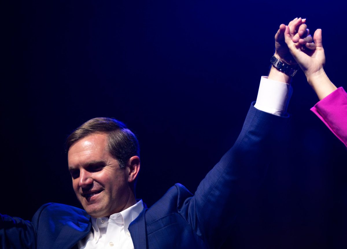 Incumbent Democratic Governor Andy Beshear holds the hand of his wife, Britainy Beshear,  after winning the 2023 Gubernatorial race at Old Forester’s Paristown Hall on Tuesday, Nov. 7, 2023, in Louisville, Kentucky. Photo by Samuel Colmar | Staff