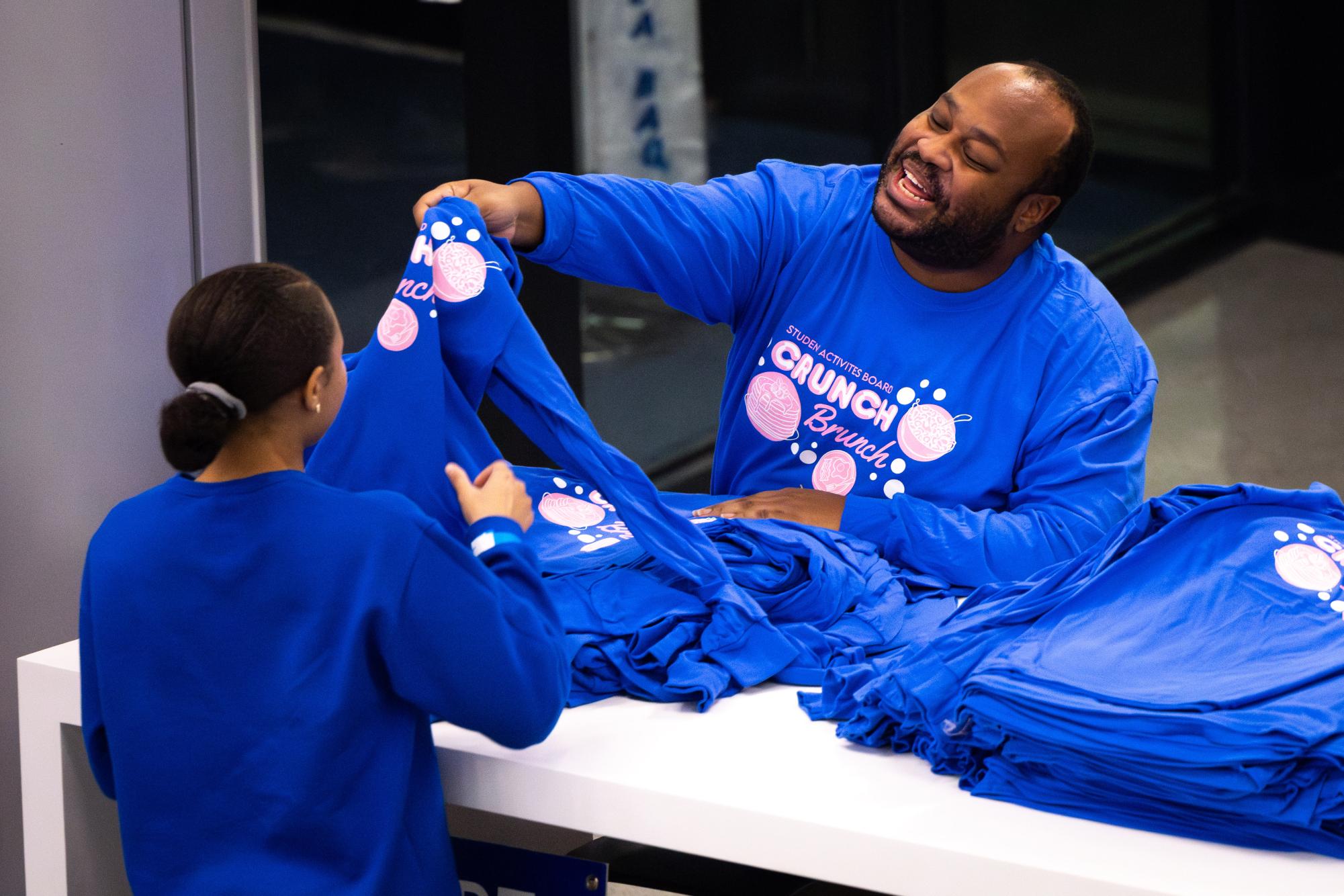 An attendee receives a t-shirt during the SAB Crunch Brunch event on Wednesday, Dec. 6, 2023, at the Gatton Student Center in Lexington, Kentucky. Photo by Samuel Colmar | Staff