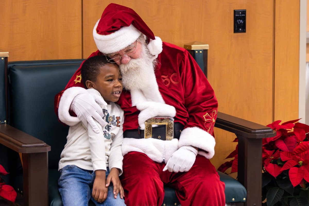 A+child+attendee+sits+with+Santa+during+the+Breakfast+with+Santa+event+on+Saturday%2C+Dec.+2%2C+2023%2C+at+the+Kentucky+Childrens+Hospital+in+Lexington%2C+Kentucky.+Photo+by+Samuel+Colmar+%7C+Staff