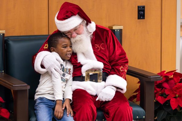 A child attendee sits with Santa during the Breakfast with Santa event on Saturday, Dec. 2, 2023, at the Kentucky Childrens Hospital in Lexington, Kentucky. Photo by Samuel Colmar | Staff
