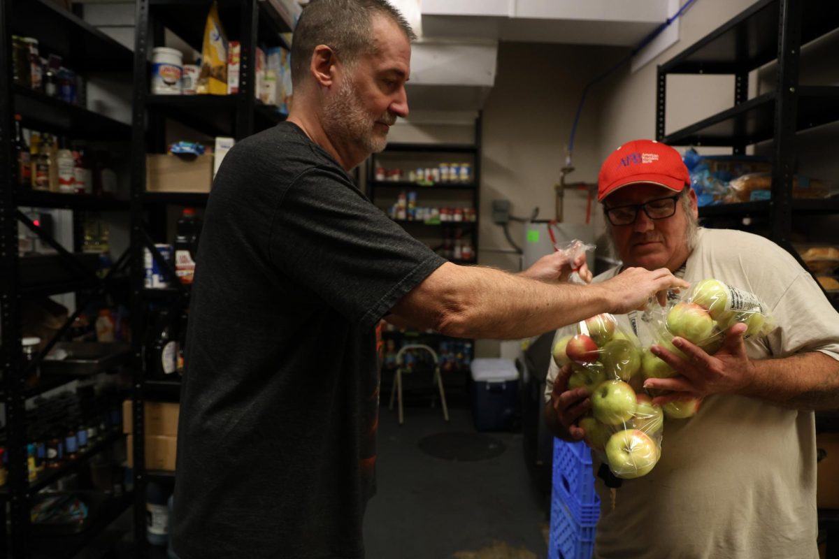 Brian Pedigo, left, hands bags of apples to Brian Friedel, who stays in the ACCESS Soup Kitchen and Men’s Shelter, on Friday, Oct. 13, 2023 in Frankfort, KY. Photo by Hannah Stanley
