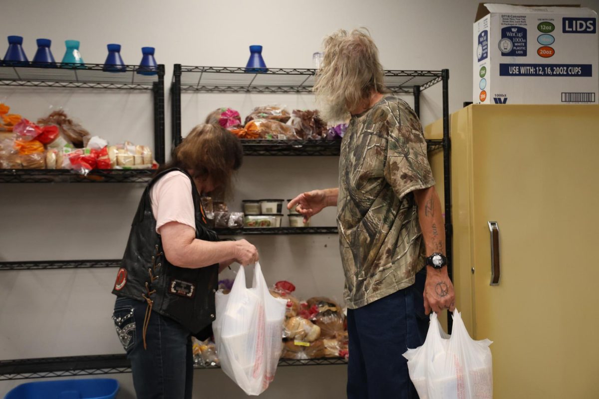 Marica Mullins, left, helps bag donated cottage cheese to a person visiting during the ACCESS Soup Kitchen and Men’s Shelter’s daily lunch on Friday, Oct. 13, 2023 in Frankfort, KY. Photo by Hannah Stanley