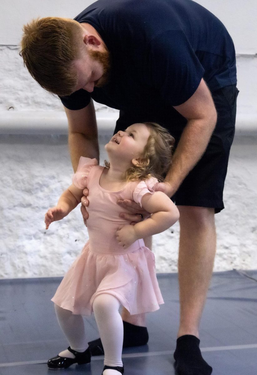 Elowen Johnson and her dad have a moment during a dance class at Kentucky Dance Academy on Thursday, Oct. 12, 2023, in Frankfort, Kentucky.