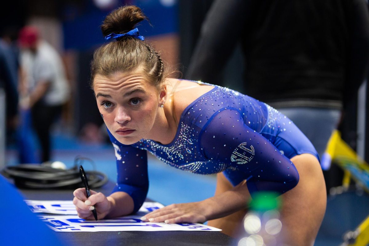 Makenzie Wilson autographs posters for fans during the No. 7 Kentucky vs. No. 18 Georgia gymnastics meet on Friday, January 26, 2024, at Rupp Arena in Lexington, Kentucky. Kentucky won 197.950-195.650. Photo by Brady Saylor | Staff