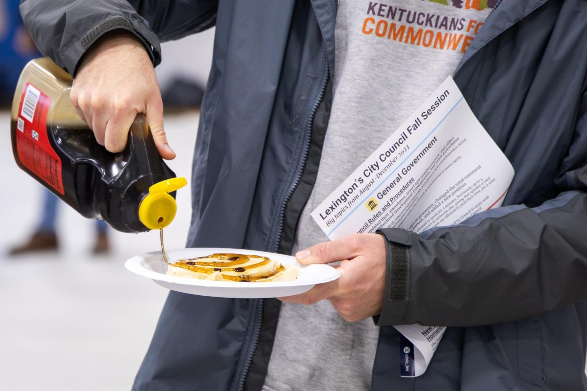 An attendee pours maple syrup on their pancakes during the CivicLex free pancake breakfast on Saturday, Jan. 27, 2024, at the Woodhill Community Center in Lexington, Kentucky. Photo by Samuel Colmar | Staff