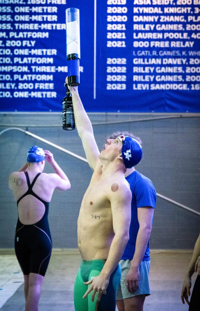 A Kentucky mens swimmer holds a t-shirt cannon to the ceiling during the Kentucky Swim & Dive Senior Night and meet against the University of Cincinnati on Friday, Feb. 2, 2024, at the Lancaster Aquatic Center in Lexington, Kentucky. Kentucky Mens swim & dive won 186-111, while Kentucky Womens swim & dive won 207-93. Photo by Cameron Guagenti