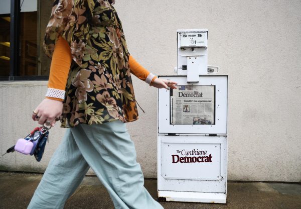 Cynthiana Democrat Regional Editor Kendall Staton walks by a newspaper stand on Tuesday, Jan. 23, 2024, outside of the Democrat office in Cynthiana, Kentucky. Staton is one of the youngest newspaper editor’s in the country. Photo by Abbey Cutrer | Staff