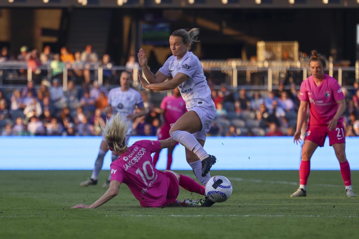Sofia Jakobsson slide tackles Lauren Millet on Saturday, April 13, 2024, at Lynn Family Stadium in Louisville, Kentucky. Racing FC tied 0-0 with San Diego Wave.  Photo by Matthew Mueller | Staff