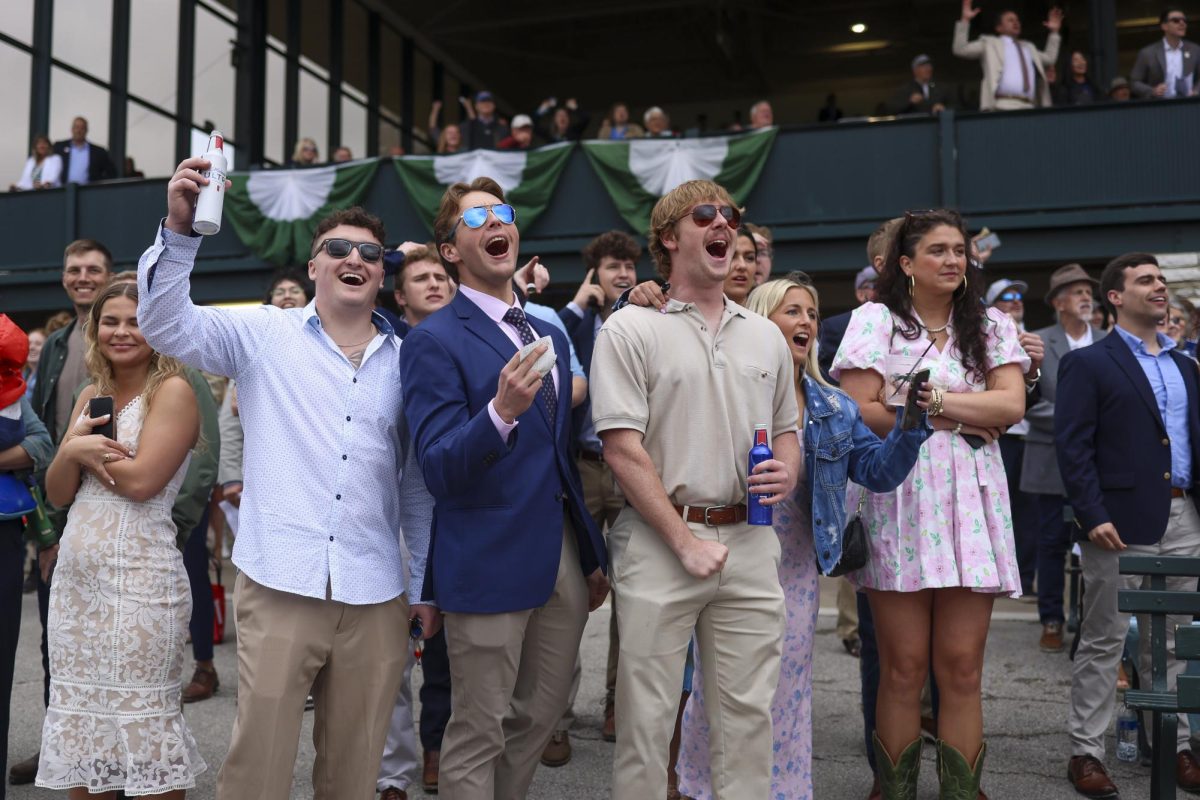 Reed Neuman and John Reese cheer as horses race by on Friday, April 19, 2024, at Keeneland During College day in Lexington, Kentucky. Photo by Matthew Mueller | Staff
