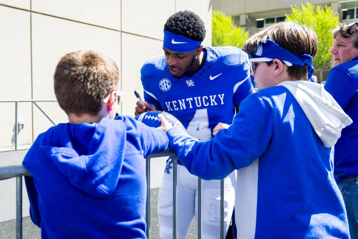 Kentucky defensive back Kristian Story (4) signs a fans football before the Kentucky Blue-White Spring football game on Saturday, April 13, 2024, at Kroger Field in Lexington, Kentucky. Photo by Samuel Colmar | Staff