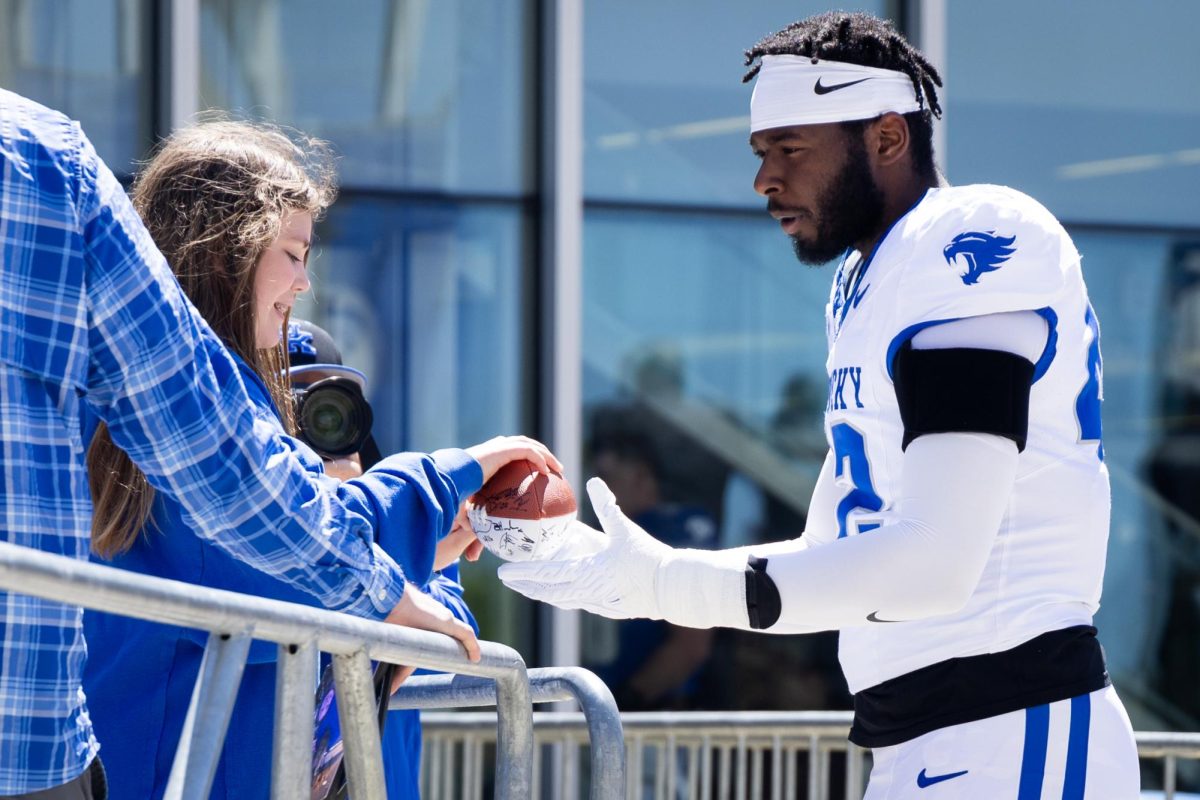 Kentucky outside linebacker Tyreese Ferry signs a football for a fan before the Kentucky Blue-White Spring football game on Saturday, April 13, 2024, at Kroger Field in Lexington, Kentucky. Photo by Samuel Colmar | Staff