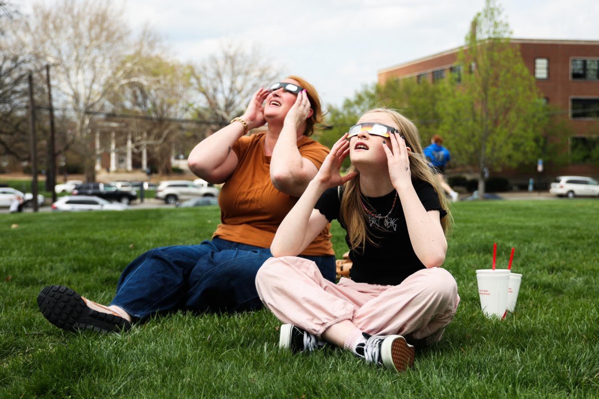 Sarah Corman, a social work graduate student, watches the partial solar eclipse with her daughter Penelope on Monday, April 8, 2024, at the University of Kentucky in Lexington, Kentucky. Photo by Abbey Cutrer | Staff