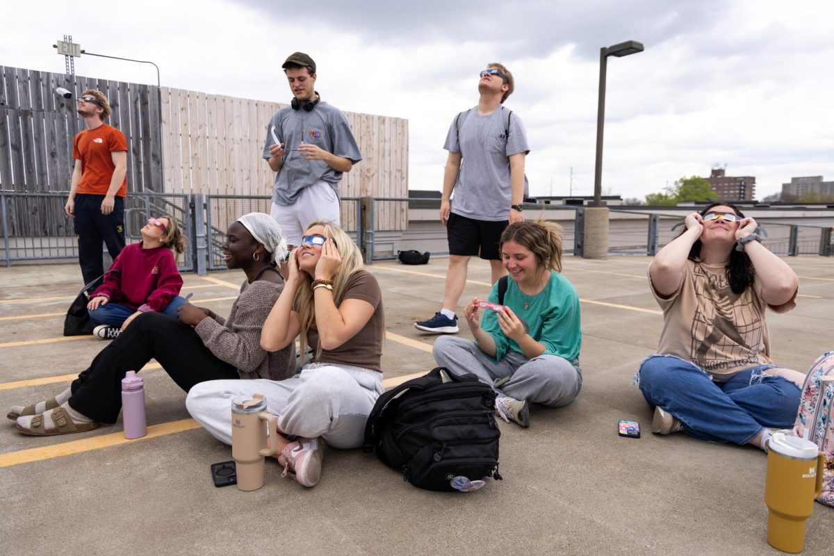 Students from the School of Visual Arts view the partial solar eclipse on Monday, April 8, 2024, on top of the Center Court Parking Garage in Lexington, Kentucky. Photo by Samuel Colmar | Staff