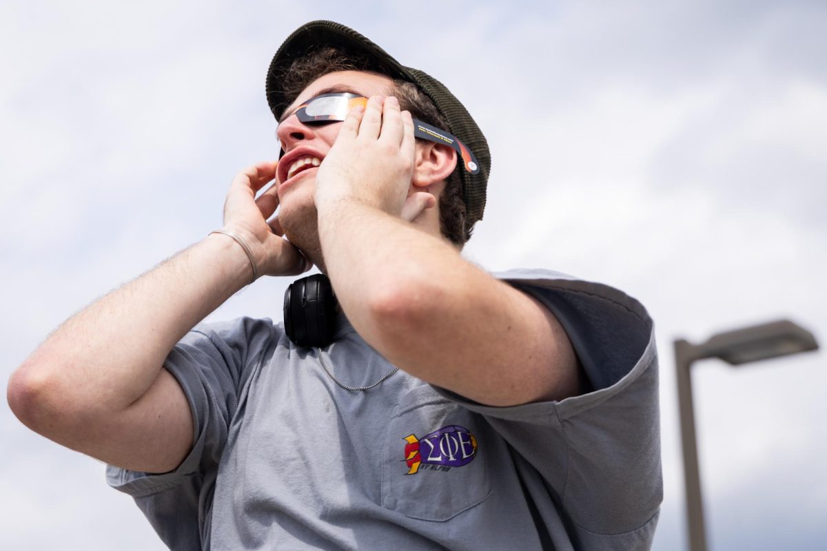 Student Carson Meyer views the partial solar eclipse on Monday, April 8, 2024, on top of the Center Court Parking Garage in Lexington, Kentucky. Photo by Samuel Colmar | Staff