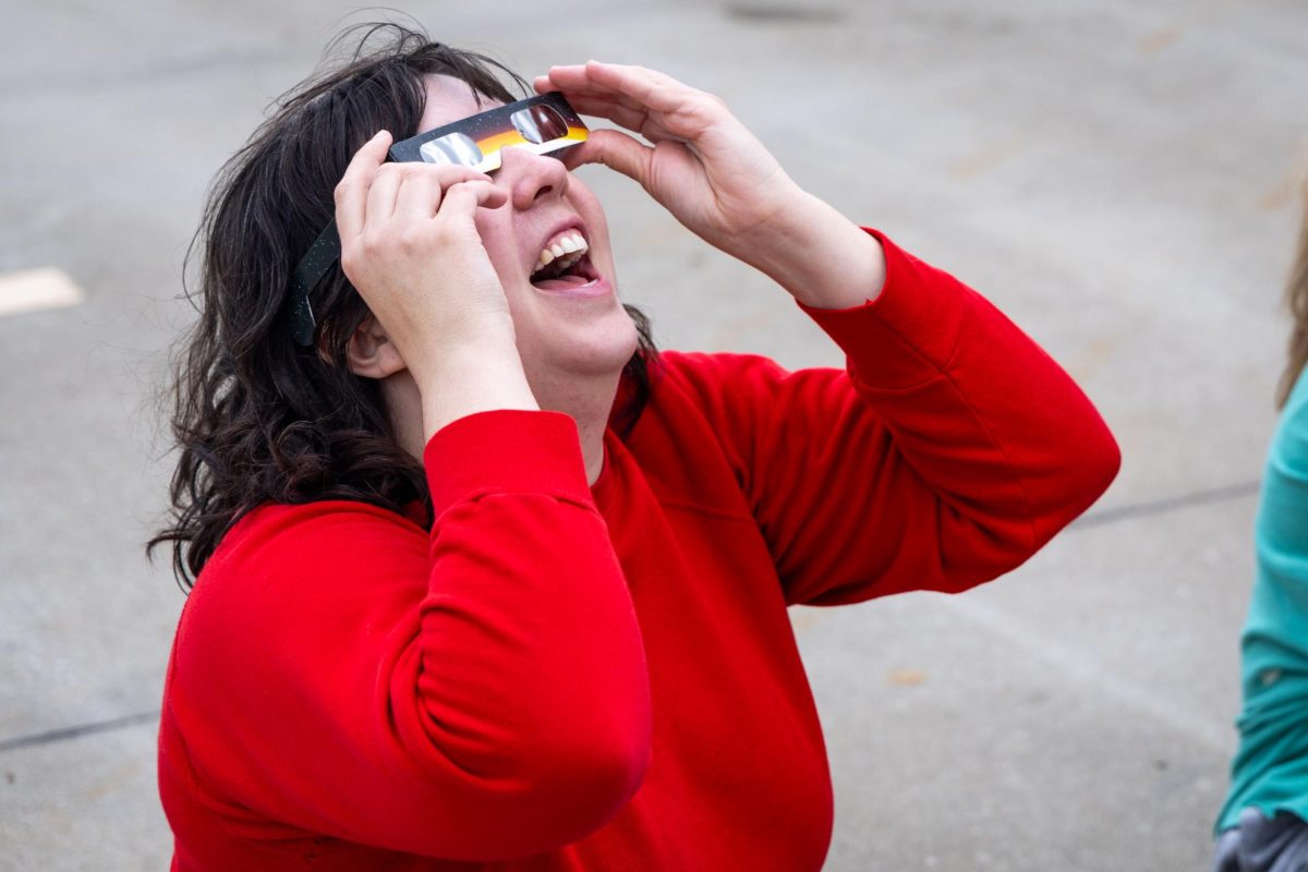 School of Visual Arts Professor Trish Gibson views the partial solar eclipse Monday, April 8, 2024, on top of the Center Court Parking Garage in Lexington, Kentucky. Photo by Samuel Colmar | Staff