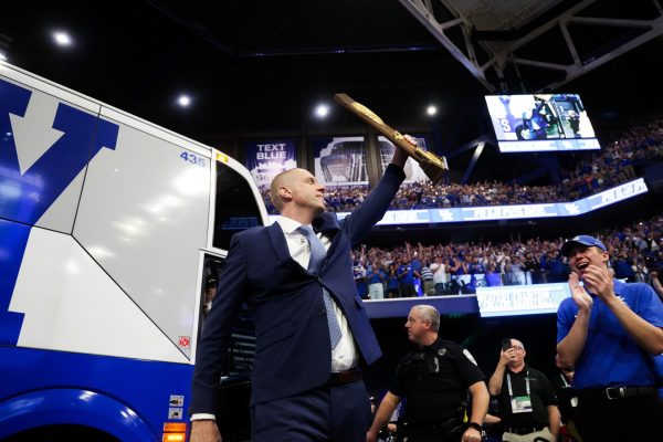 Mark Pope holds up his championship trophy from 1996 as he is introduced at his press conference as the new head coach of Kentucky men’s basketball on Sunday, April 14, 2024, at Rupp Arena in Lexington, Kentucky. Photo by Abbey Cutrer | Staff