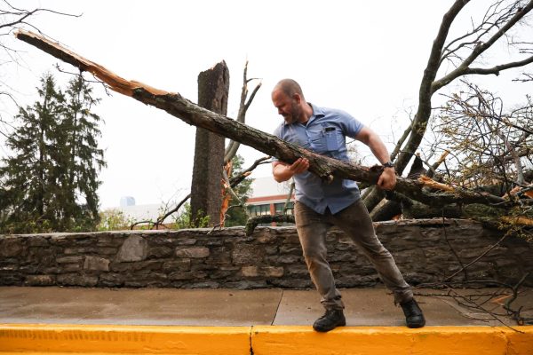 Tom Fricker, a UK groundskeeper, lifts branches out of the road behind the Whitehall Classroom Building and Patterson Office Tower after severe storm damage on Tuesday, April 2, 2024, at the University of Kentucky in Lexington, Kentucky. Photo by Abbey Cutrer | Staff