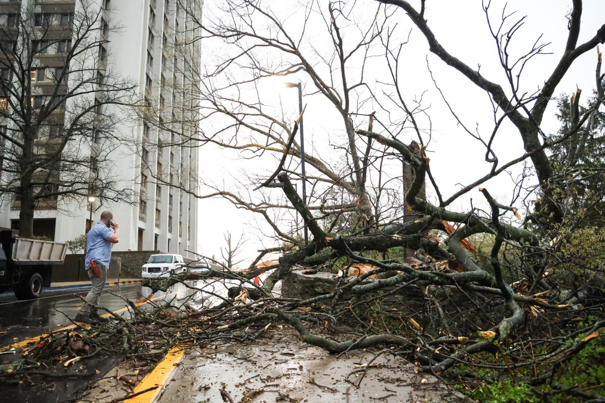 Tom Fricker, a UK groundskeeper, talks on the phone on the road behind the Whitehall Classroom Building and Patterson Office Tower in front of tree damage on Tuesday, April 2, 2024, at the University of Kentucky in Lexington, Kentucky. Photo by Abbey Cutrer | Staff
