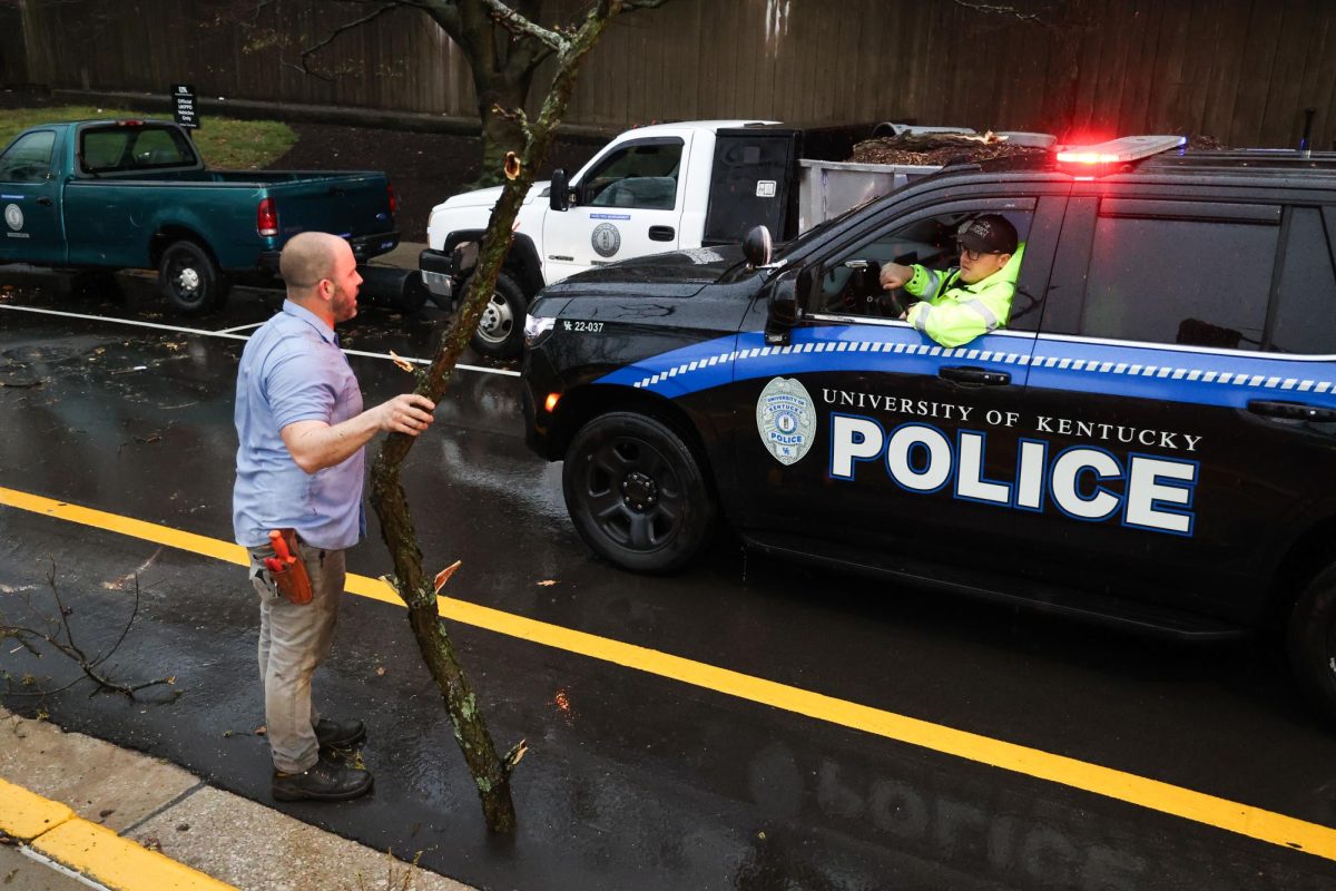 Tom Fricker, a UK groundskeeper, talks with a police officer on the road behind the Whitehall Classroom Building and Patterson Office Tower in front of tree damage on Tuesday, April 2, 2024, at the University of Kentucky in Lexington, Kentucky. Photo by Abbey Cutrer | Staff