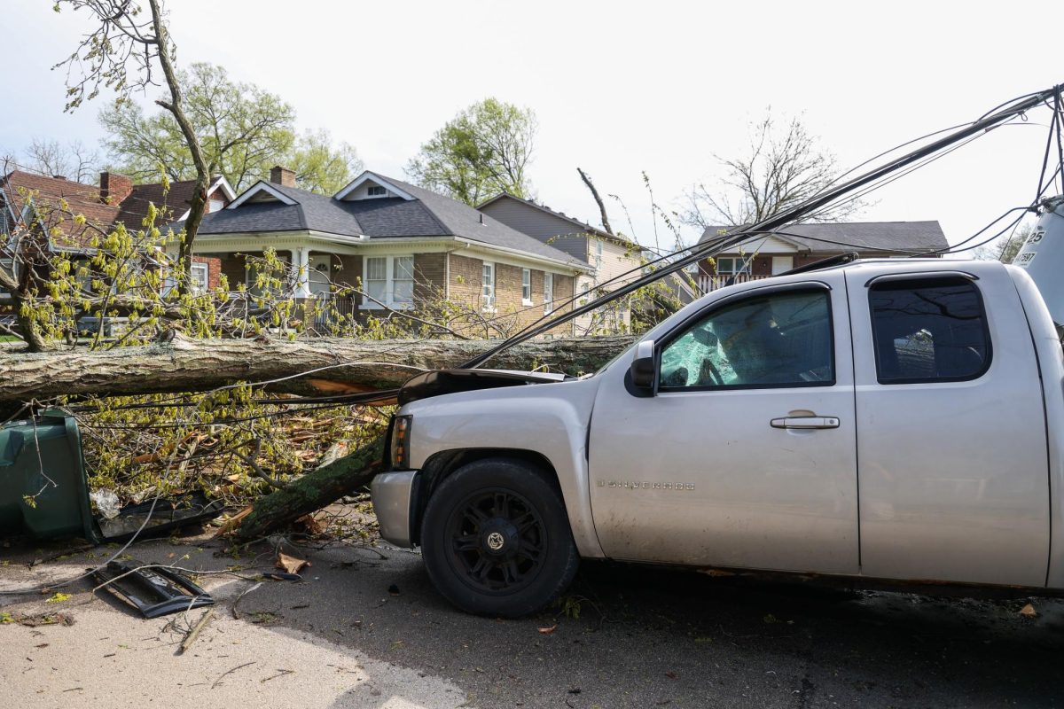 Uk student Mary Ivanov walks past a car crushed by a tree and telephone pole after severe weather on Tuesday, April 2, 2024, on University Avenue in Lexington, Kentucky. Photo by Abbey Cutrer | Staff