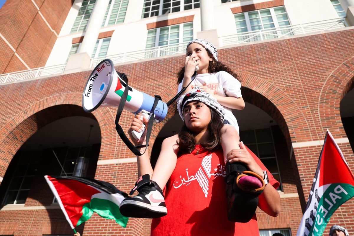 Nour Shalash chants as she sits on the shoulders of her cousin Jenna Shalash during a solidarity rally for Gaza on Wednesday, May 1, 2024, outside of the William T. Young Library at the University of Kentucky in Lexington, Kentucky. Photo by Abbey Cutrer | Staff