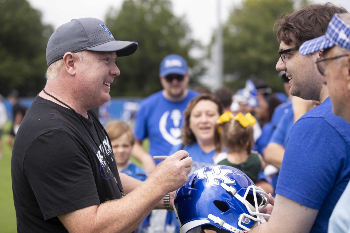 Head Coach Mark Stoops signs a fans helmet during Kentucky Football’s media day on Saturday, Aug. 3, 2024, at Kroger Field in Lexington, Kentucky. Photo by Matthew Mueller | Photo Editor