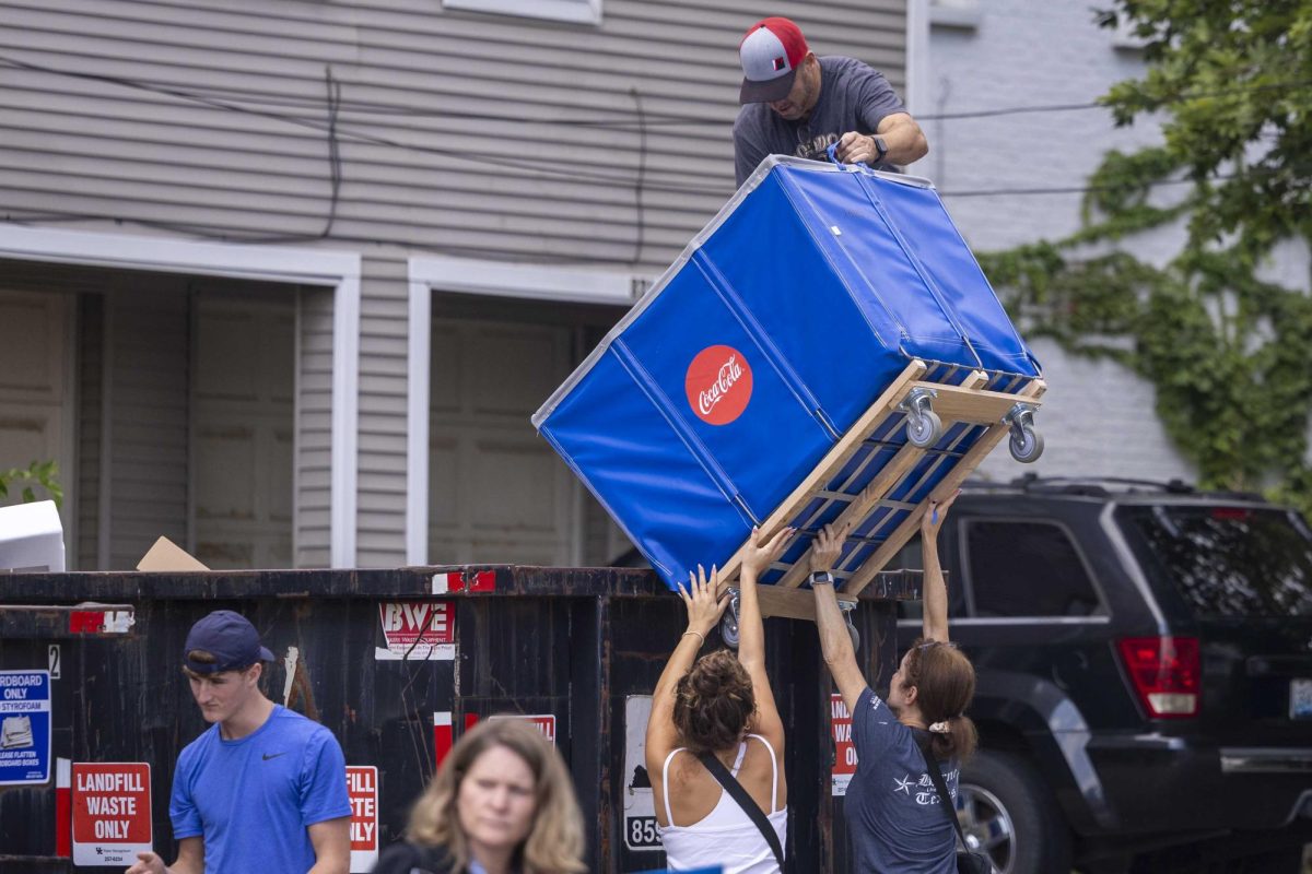 Freshman Amelia Hall, 18, majoring in Political Science helps her father pour trash from a move-in cart into a dumpster on Monday, Aug. 19, 2024, at the University of Kentucky in Lexington, Kentucky. During Big Blue Move-In. Photo by Matthew Mueller | Photo Editor  