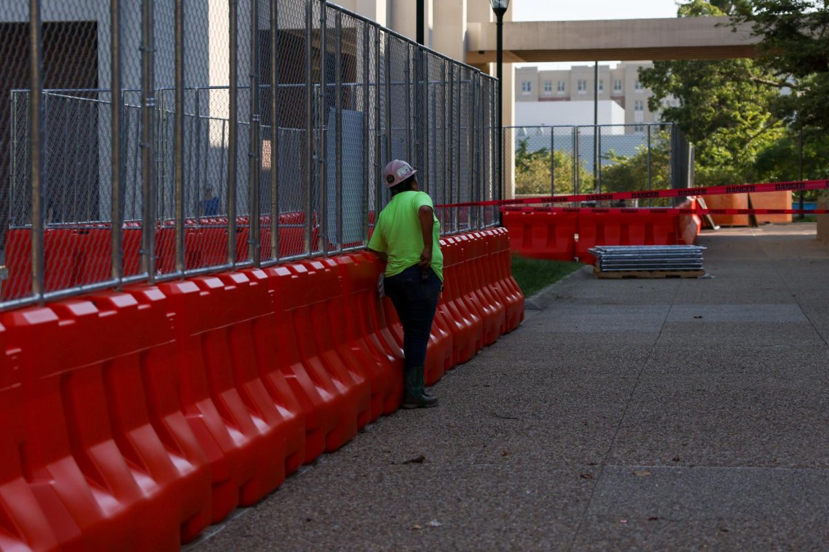 Construction worker looks at White Hall Building during the first day of classes on Aug. 26, 2024, in Lexington, Kentucky. Photo by Sydney Yonker | Staff