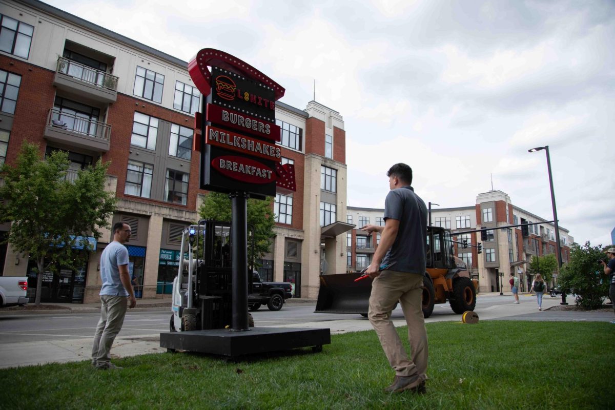 Workers secure the L8nite sign with a forklift outside Cornerstone Garage on Wednesday, Sep. 4, 2024, in Lexington, Kentucky. The sign is being torn down. Photo by Christian Kantosky | Staff