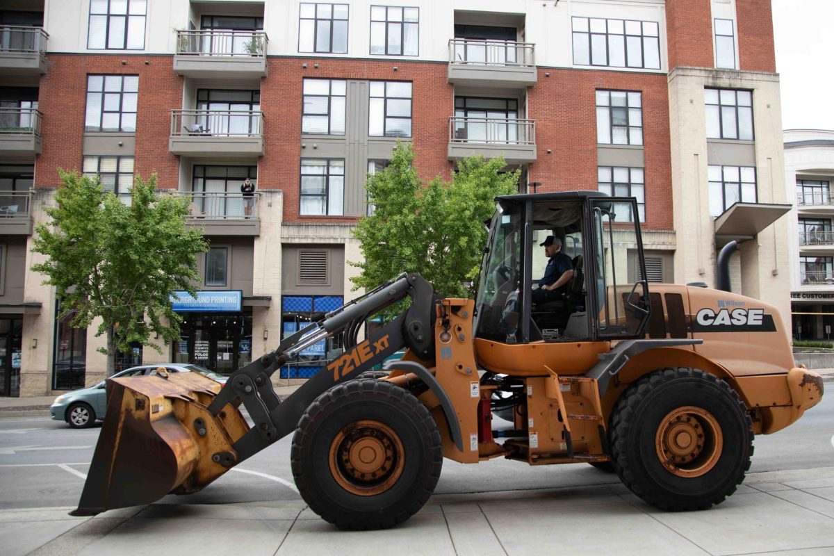 A bulldozer waits for the L8nite sign to be secured before its' demolition outside Cornerstone Garage on Wednesday, Sep. 4, 2024, in Lexington, Kentucky. Photo by Christian Kantosky | Staff