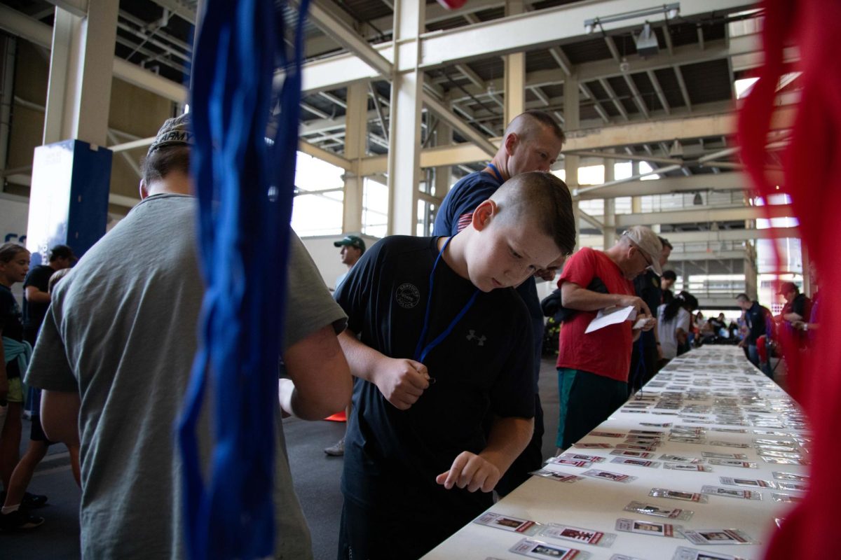 A child chooses which fallen hero he wants to represent at the 9/11 Memorial Stair Climb on Wednesday, Sept. 11, 2024, at Kroger Field in Lexington, Kentucky. Photo by Christian Kantosky | Staff