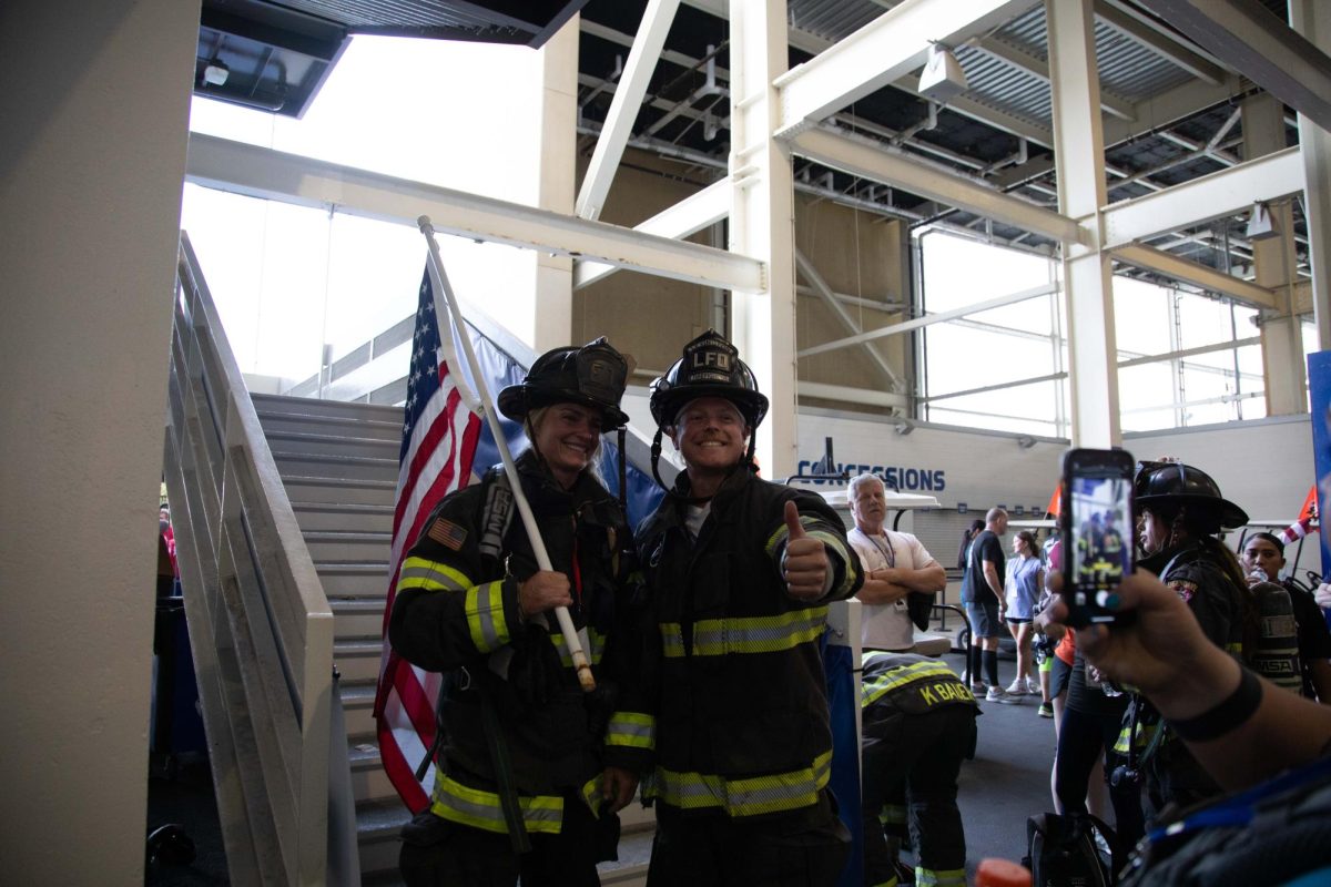 The two firefighters who lead the march pose for a photo before the 9/11 Memorial Stair Climb on Wednesday, Sept. 11, 2024, at Kroger Field in Lexington, Kentucky. Photo by Christian Kantosky | Staff