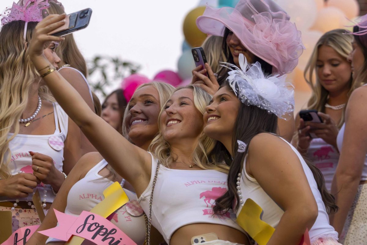 Members of Alpha Delta Pi take a selfie outside of their house while waiting for new members to arrive during bid day on Monday, Sept. 9, 2024, at Greek Row in Lexington, Kentucky. Photo by Matthew Mueller | Staff