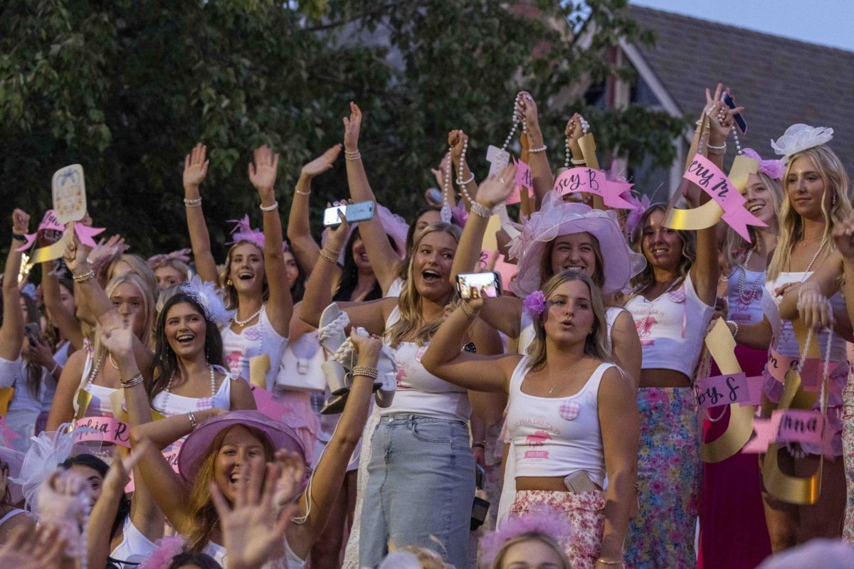 Members of Alpha Delta Pi cheer as new members pass by in buses to arrive during bid day on Monday, Sept. 9, 2024, at Greek Row in Lexington, Kentucky. Photo by Matthew Mueller | Staff